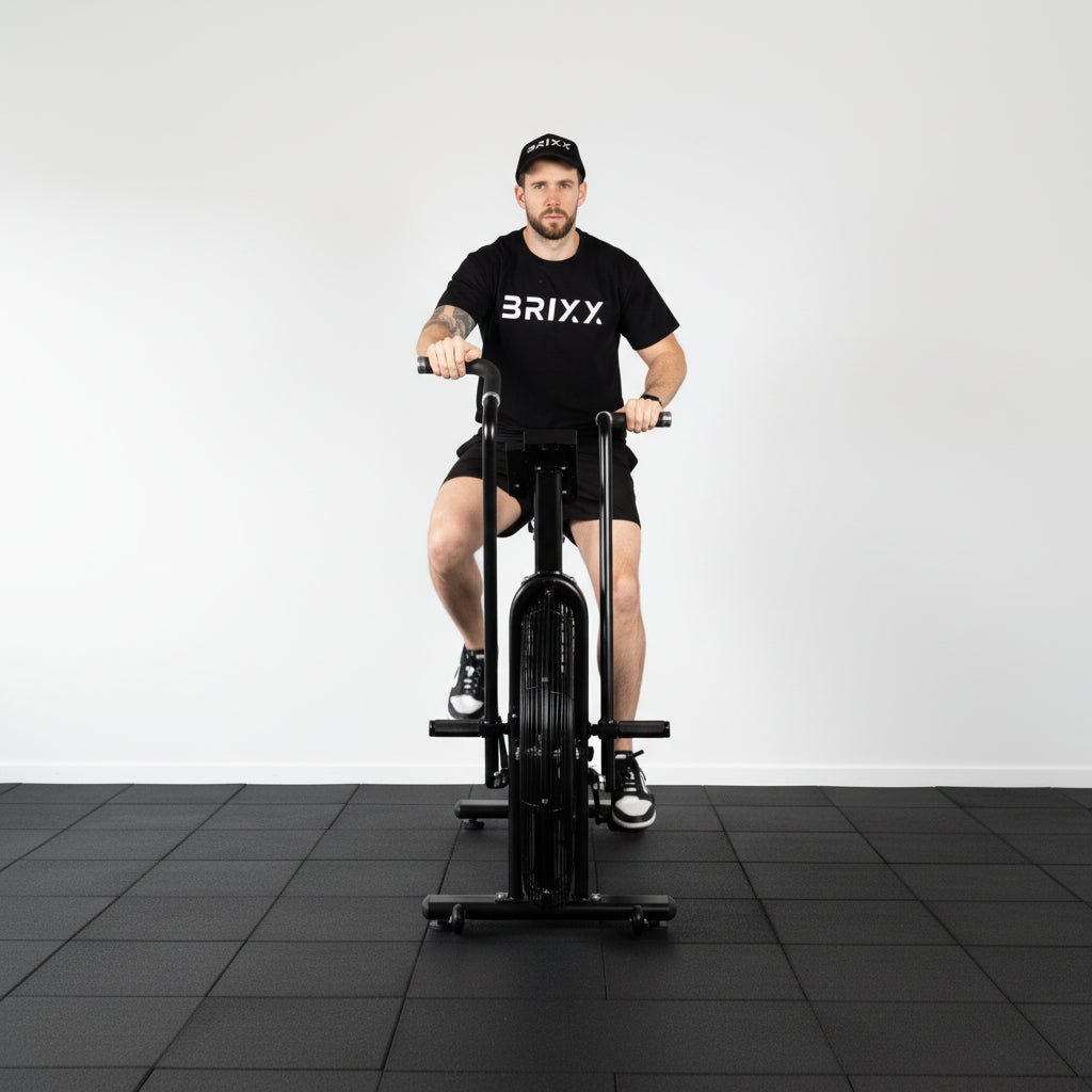 Person using a black exercise bike with 'BRIXX' branding on a white background