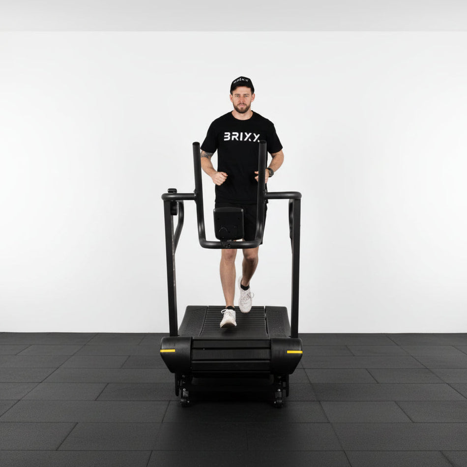 Person wearing a black 'BRIXX' t-shirt running on a treadmill against a white background